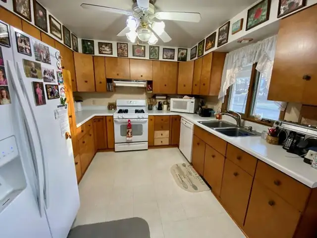 U-shaped kitchen with refaced oak cabinets, light countertops and a double sink under the window